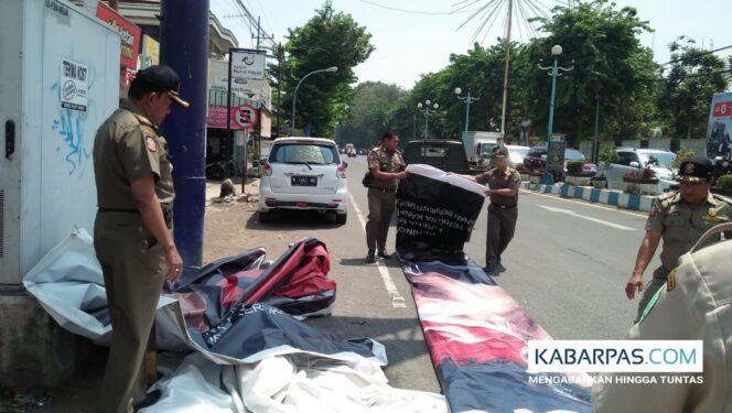 
Satpol PP Pasuruan Copot Paksa Reklame Tak Berizin