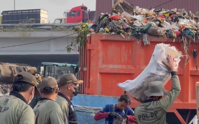 
Satpol PP Jakut Sigap Bantu Atasi Sampah di TPS Waduk Cincin yang Meluber ke Jalan